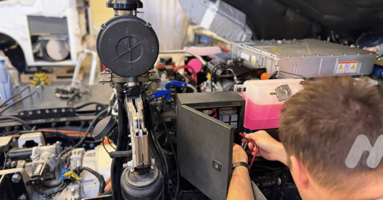 Technik MIP pracuje na odkrytej technickej časti vodíkového pohonného systému počas prípravy vozidla.
